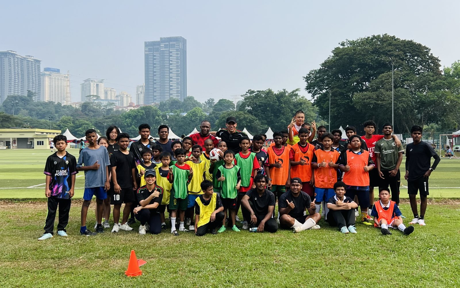 The full Beyond 90 squad and coaches, KL skyline behind