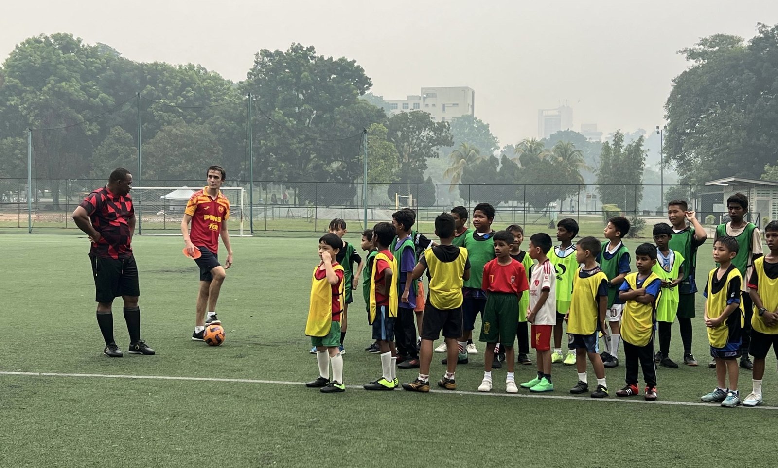 Coaches briefing a lined-up group of children before a session
